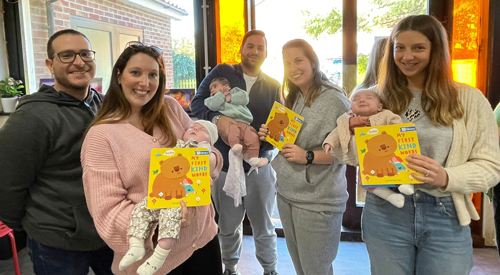 Families holding books and babies