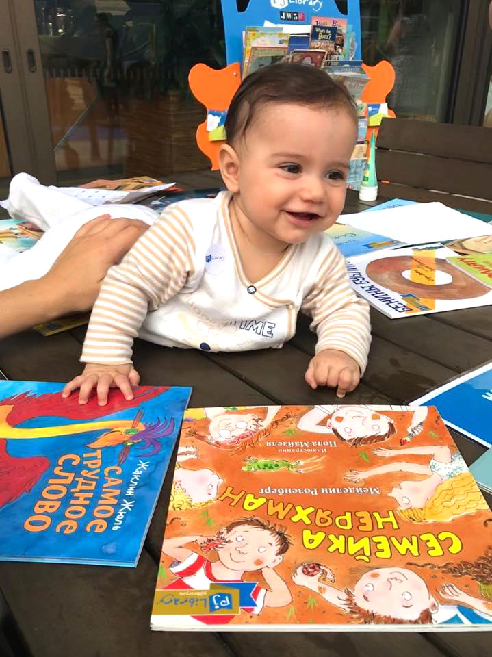 A baby is playing with books