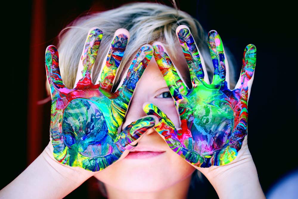 child with paint on their hands