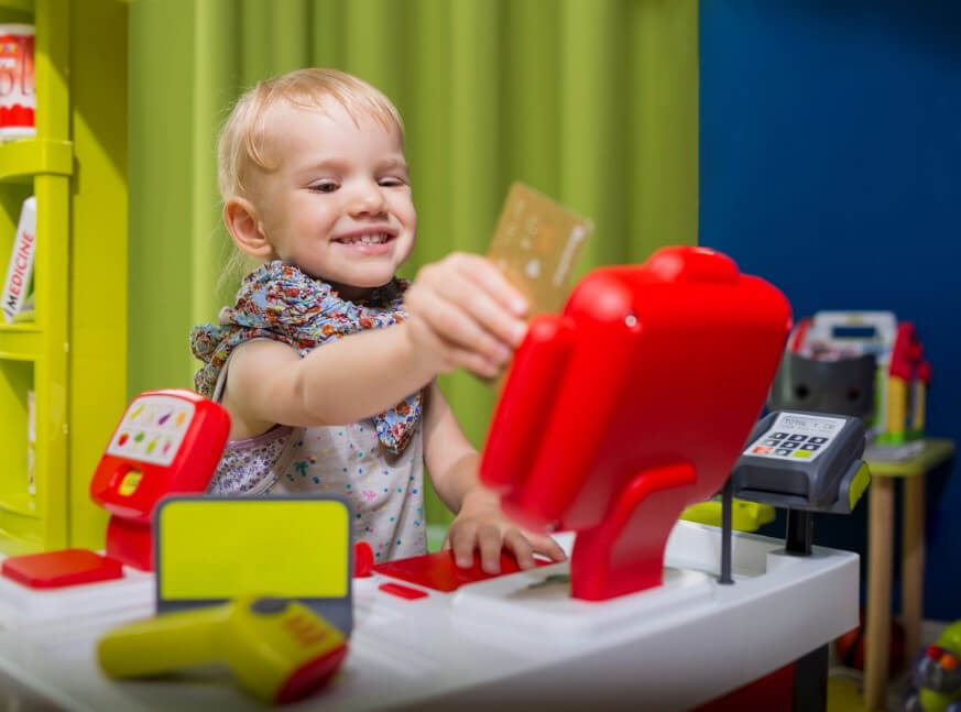 Child plays at toy supermarket cash register