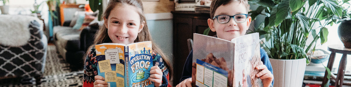 Two siblings happily reading together