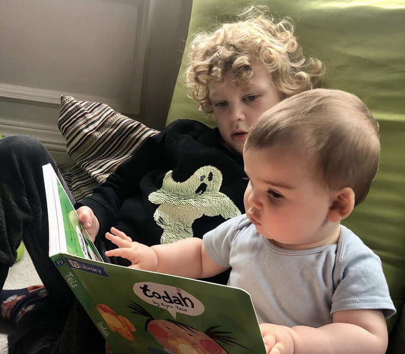 Two young children reading a book