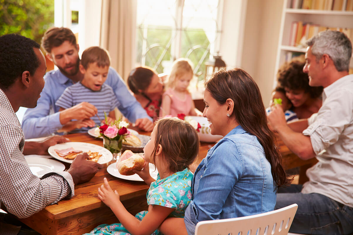 Freinds and Family Sitting Around a Table Eating